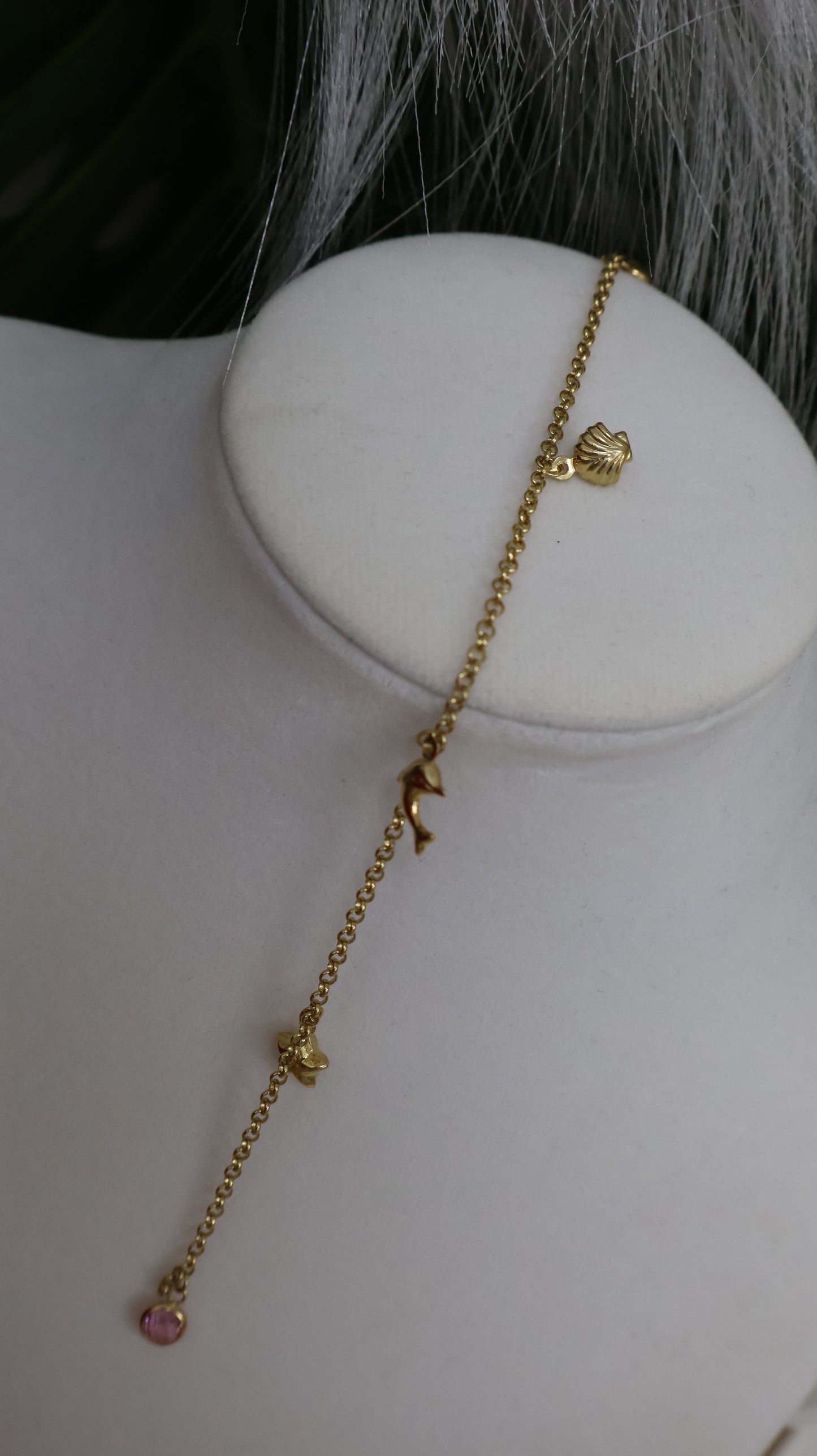 Manilla para ninas con colgantes de un delfin , una concha ,una estrellita y dos piedrita en oro de 10k