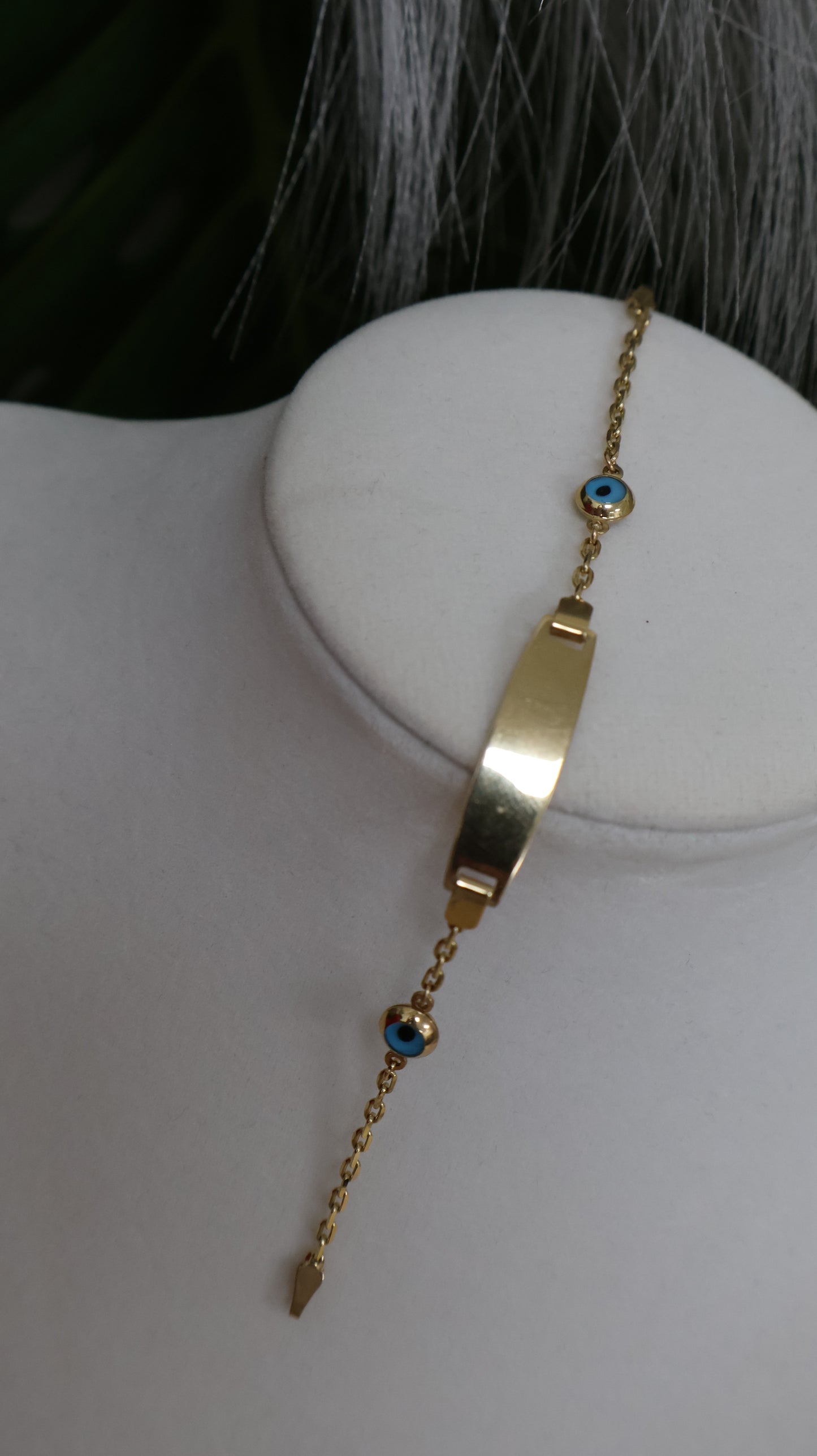 Manilla de nino con placa de ojitos en azul en oro de 14k