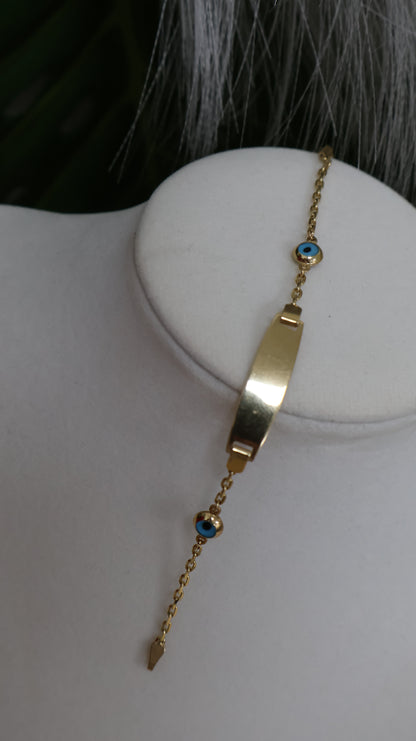 Manilla de nino con placa de ojitos en azul en oro de 14k